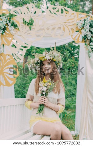 Beautiful woman with a wreath on her head from real flowers.