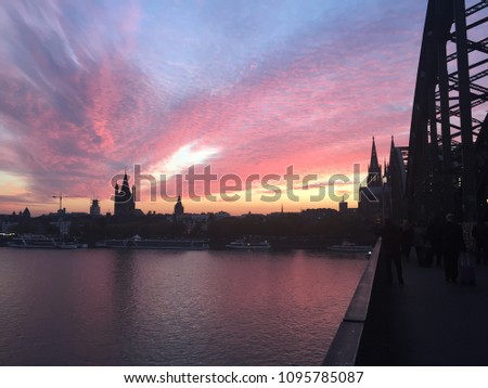 Sunset in Cologne. View on the cathedral and the Hohenzollern bridge over the Rhein river in Koln