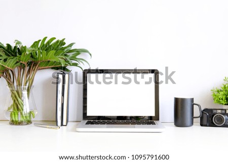 Mock up laptop computer on work space with mug of coffee, plat in pot and notebook paper copy space office table.