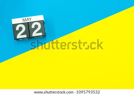 May 22nd. Day 22 of may month, calendar on blue and yellow background flat lay, top view. Spring time. Empty space for text