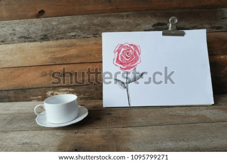 Red rose flower illustration by crayons,hand drawing on white paper,decorative series with pen line,leaning on a wood wall,with color pencil and white coffee cup on old wood,dark tone,rural style.