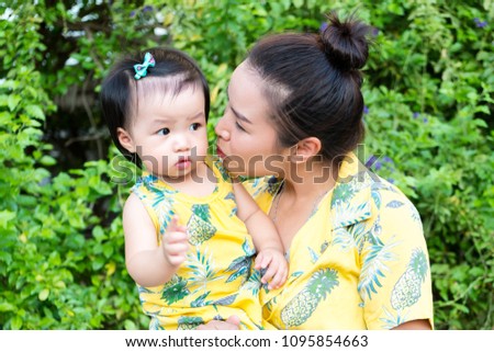 Happy family on a summer. Mother kissing little girl child baby daughter 