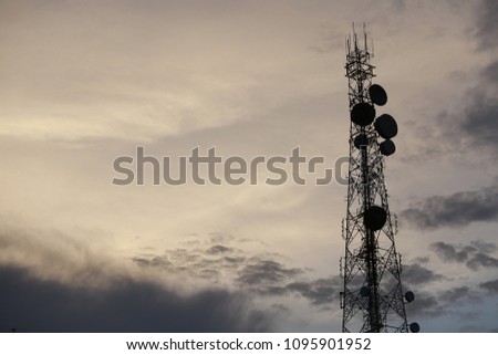 Telecommunication tower Antenna and satellite dish at sunset sky background.