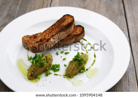Gourmet snack, traditional Italian cuisine, restaurant menu, food photo concept. Chef's olive tapenade and rye baguette in restaurant serving