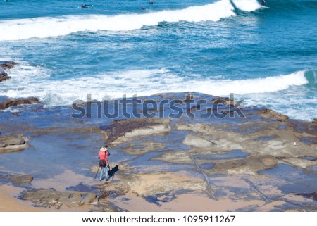 Photographer with a tripod taking pictures of surfers, Newcastle Beach, Newcastle, Australia