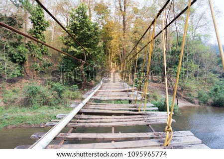 Suspension bridge, Crossing the river, ferriage in the woods Royalty-Free Stock Photo #1095965774