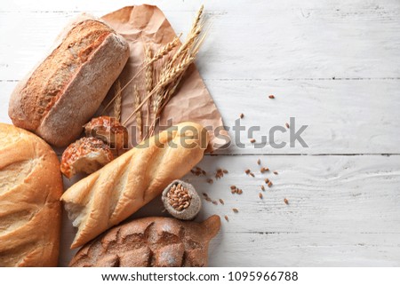 Different bakery products on wooden background Royalty-Free Stock Photo #1095966788