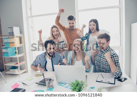 Cheerful, glad, joyful, lucky, stylish, positive, attractive business people looking at screen of laptop with raised hands shouting yelling celebrating successfully completed project, enjoying results Royalty-Free Stock Photo #1096121840