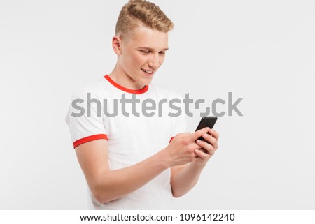 Photo of modern youngster wearing casual clothing typing or scrolling social networking on cell phone isolated over white background