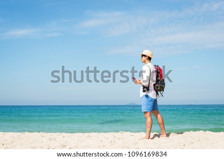 Asian young traveler looking to the beach sky, enjoying the beach, summer holidays, and the concept of vacationing on holiday.Summer and Travel Concept.