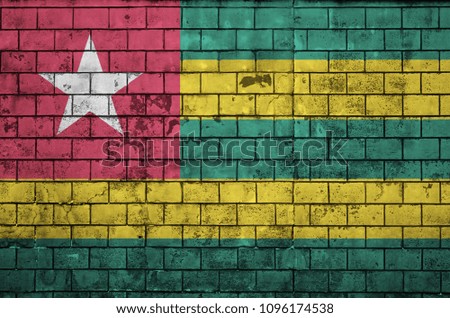 Togo flag is painted onto an old brick wall