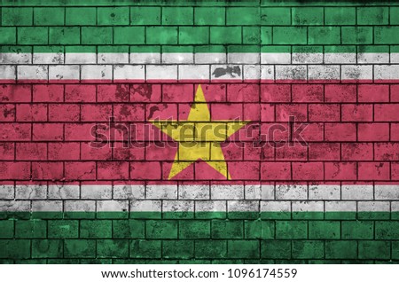 Suriname flag is painted onto an old brick wall