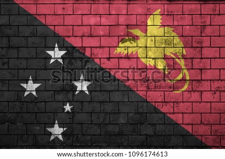 Papua New Guinea flag is painted onto an old brick wall