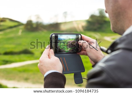 a tourist taking pictures of Hadleigh Park (Essex, UK) with his smartphone