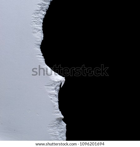 torn edge of white plastic on black