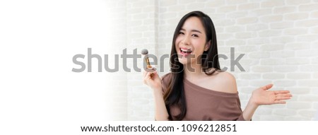 Young beautiful Asian woman professional beauty vlogger or blogger  doing a make up tutorial, panoramic banner with copy space