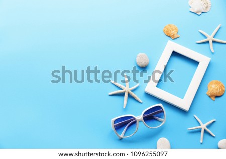 picture frame with starfish,Shell,sunglasses on blue table In the summer Asia,copy space,minimal style