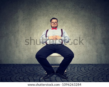 Obese man in formal outfit having sedentary way of living looking lazy on gray background. 