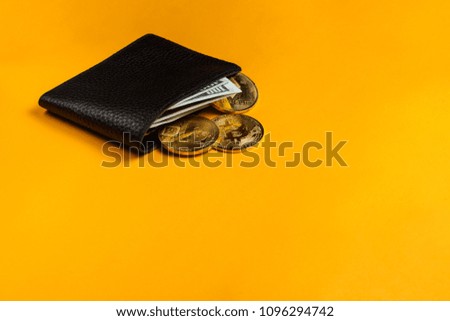 Crypto-currency in the physical purse. The concept of virtual money in the wallet. On a yellow background.