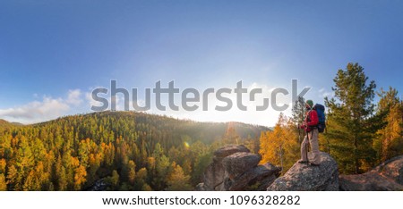Backpacker on top of a rock fall at dawn panorama Royalty-Free Stock Photo #1096328282
