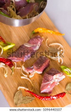 Appetizer pieces lamb on wooden board, decorated peppers and onions. Kitchen background. Close up concept. Meat grill. Beautiful restaurant. Nature food. Tradition bbg. 