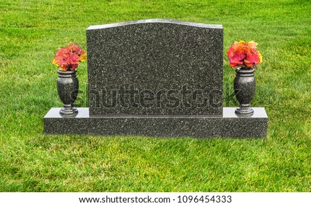 Single blank tombstone with flowers Royalty-Free Stock Photo #1096454333