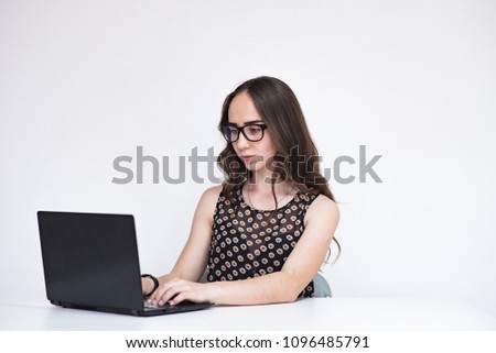 Tell me about your illnesses. Portrait of beautiful brunette manager girl on white background with laptop. She sits right in front of the camera smiling and looks serious