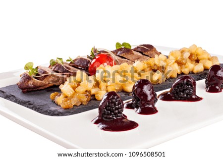 Baked, juicy, tasty beef with vegetables and sauce. Dish from the chef. Meat  cooked on fire and served on a white plate. Photo for the restaurant menu. Food photography. isolated white background tif