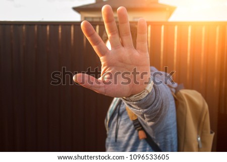  Man hiding his face from camera because of privacy GDPR on summer sunset .