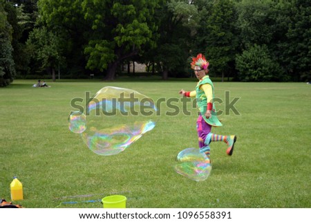 Circus juggler portrait. Clown making giant bubble(s). 