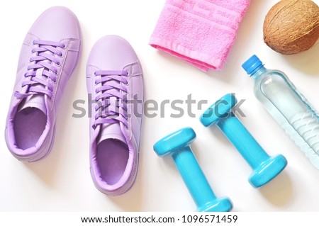 Purple sneakers, pink towel, coconut, blue dumbbells and mineral water bottle. Fitness mockup. Gym, healthy lifestyle flat lay photography