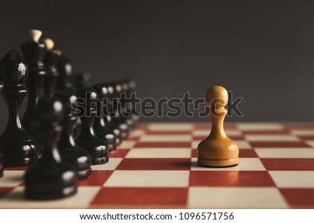 One pawn standing against set of black chess. Alone against many enemies, symbol of difficult fight or struggle, confidence concept Royalty-Free Stock Photo #1096571756