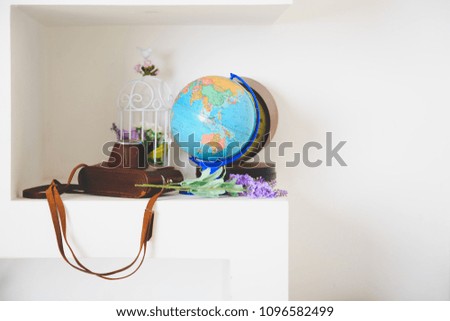 Travel concept design, globe and retro camera on white table
