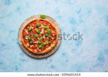 Pizza margherita on the chalk board with copy space on the blue table.