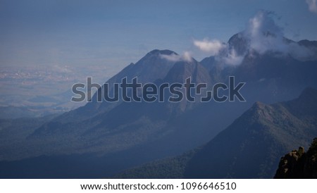Tropical green forest landscape on a high mountain with horizon to background and clouds on top of mountain in Brazil.