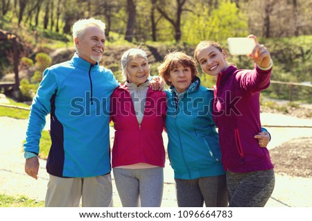 Selfie time. Pretty cheerful woman smiling and taking pictures with her family