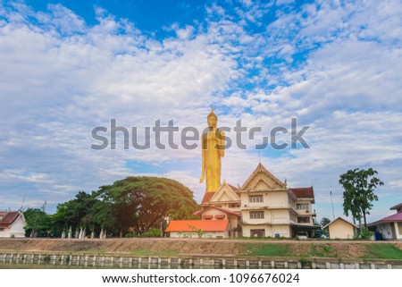 Big Buddha with the beautiful sky cloud, with the beam, light and lens flare effect tone background.The public properties at Wat Burabha Temple, Muang District, Roi Et Province, Thailand.