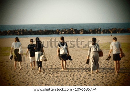 Blurred picture of girls group that are going to the beach with bare feet.