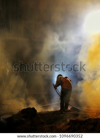 A man cuts the steel skull by oxygen lance in the steel mill