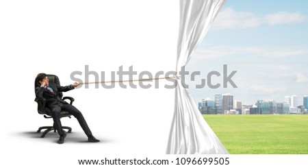 Businessman sitting in chair and pulling white blank fabric. Place for text