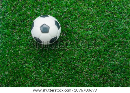 Table top view aerial image soccer or football season background.Flat lay object ball on the artificial green grass wallpaper.Free space for creative design mock up text and wording or content.