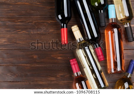 Wine bottles on wooden table. Red, rose and white wine. Top view with space for your text