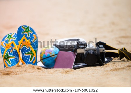 selective focus of camera ,passport ,flip flop on sand Beach ,Travel summer concept
