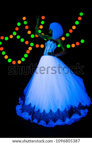 Wedding photo session of the bride Neon photography bright colorful on a dark background in ultraviolet rays young girl in white wedding dress posing in vogue style