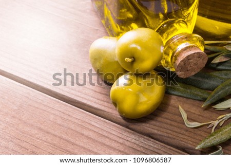 olives and bottle of extra virgin olive oil on wooden background