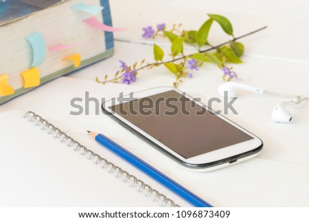 notebook with mobile phone and dictionary book for study of student on table white