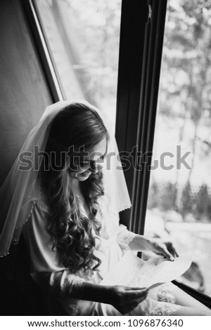 Wedding day. Fees at hotel. Room in style of Morocco. The bride sits at window and reads letter to groom. Wedding vows. Preparations. Morning of the bride. Dress with lace. Black and white photo