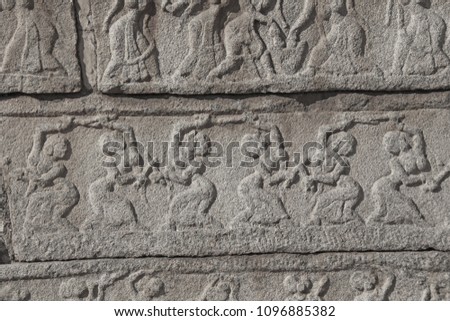 Stone bas-reliefs on the walls in Temples Hampi. Carving stone ancient background. Carved figures made of stone. Unesco World Heritage Site. Karnataka, India. Gray background. Royal enclosure.