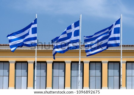 Greece, Athens: National flags wave in front of famous Zappeion building in the city center of the Greek capital and part of  National Gardens with blue sky in the background - concept nation