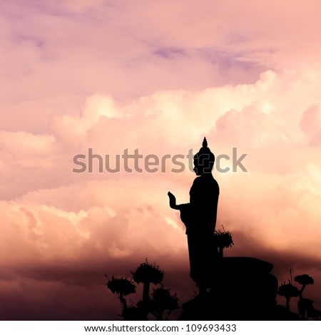 Buddha silhouette on sunset sky.
